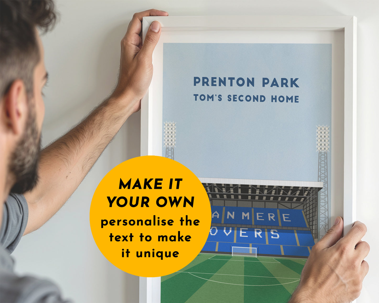 Person holding a framed picture of a stadium with text 'Prenton Park Tom's Second Home' and a call to action to personalize the text.