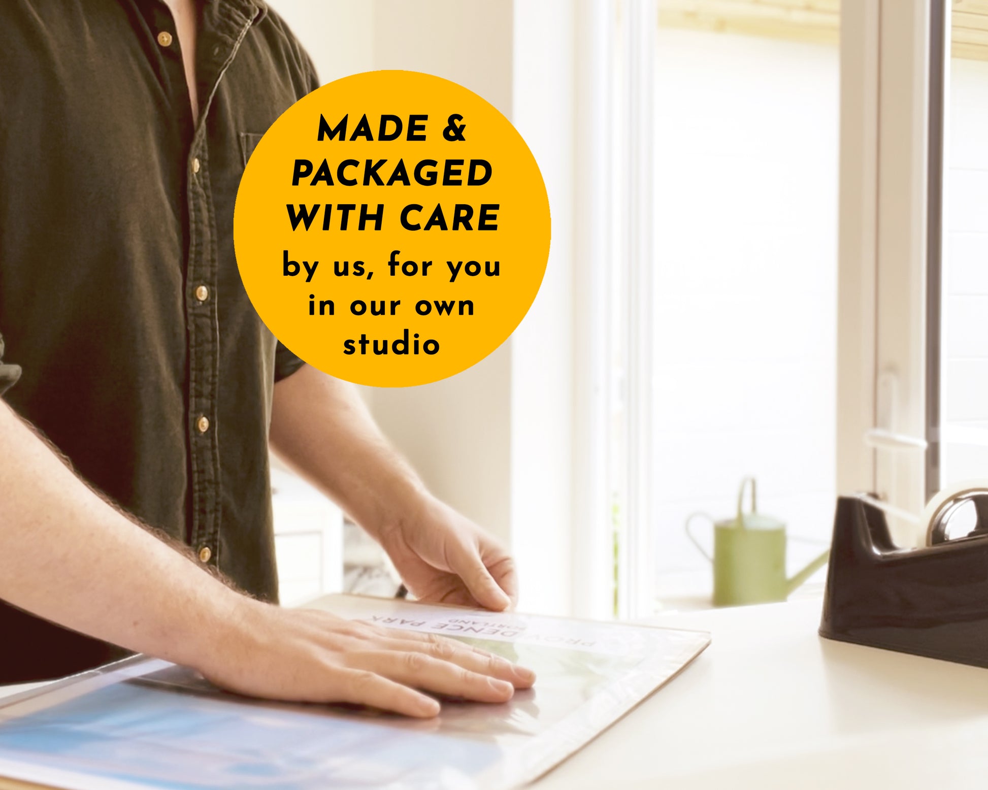 Person carefully packaging a print  with overlay text 'MADE & PACKAGED WITH CARE by us, for you in our own studio'.