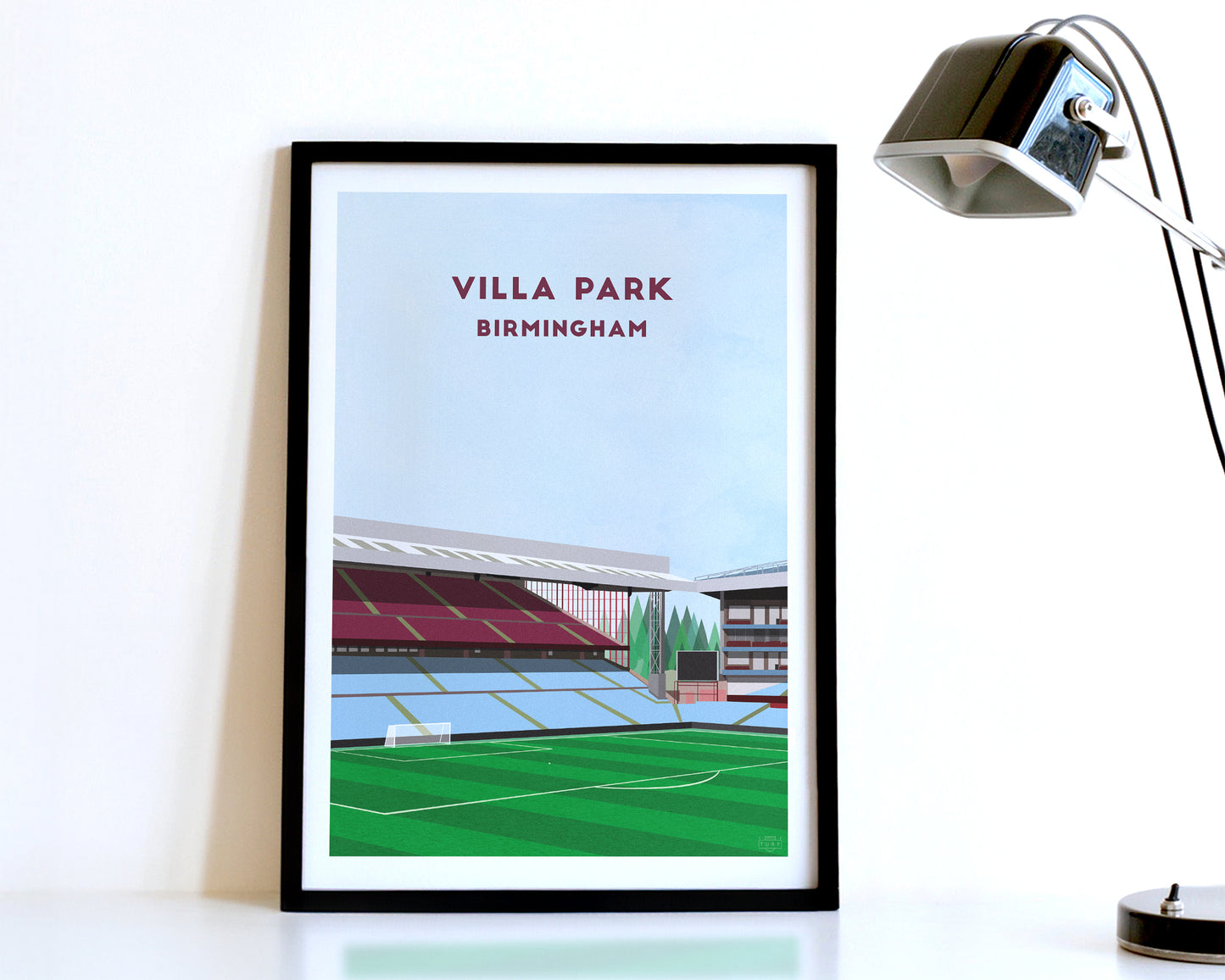 A modern style Aston Villa Poster, featuring a contemporary illustration of their home stadium the Villa Park in Birmingham, displayed within a black frame.