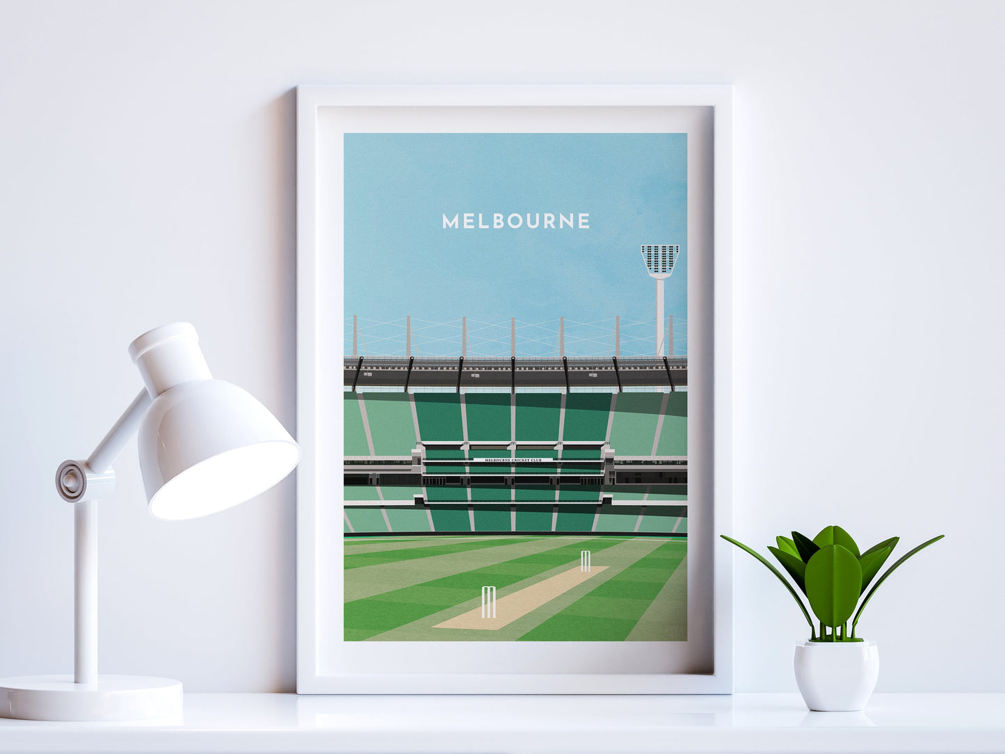 A contemporary style illustration of Australia and Melbourne's cricket stadium, the MCG, displayed as an art print within a white frame in a minimalist home office setting.