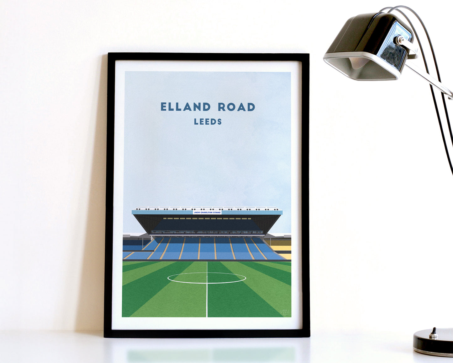 A modern style Leeds United Print, featuring a contemporary illustration of their home stadium the Elland Road in Leeds, displayed within a black frame.