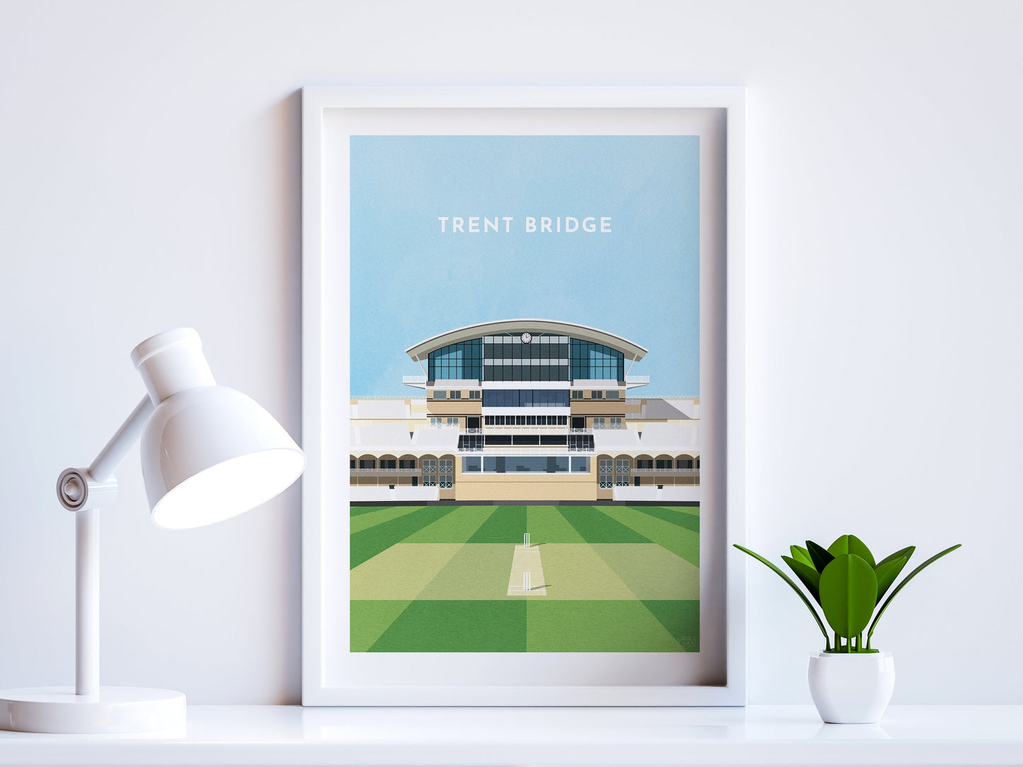 A contemporary style illustration of Nottinghamshire County Cricket's ground, Trent Bridge, displayed as an art print within a white frame in a minimalist home office setting.
