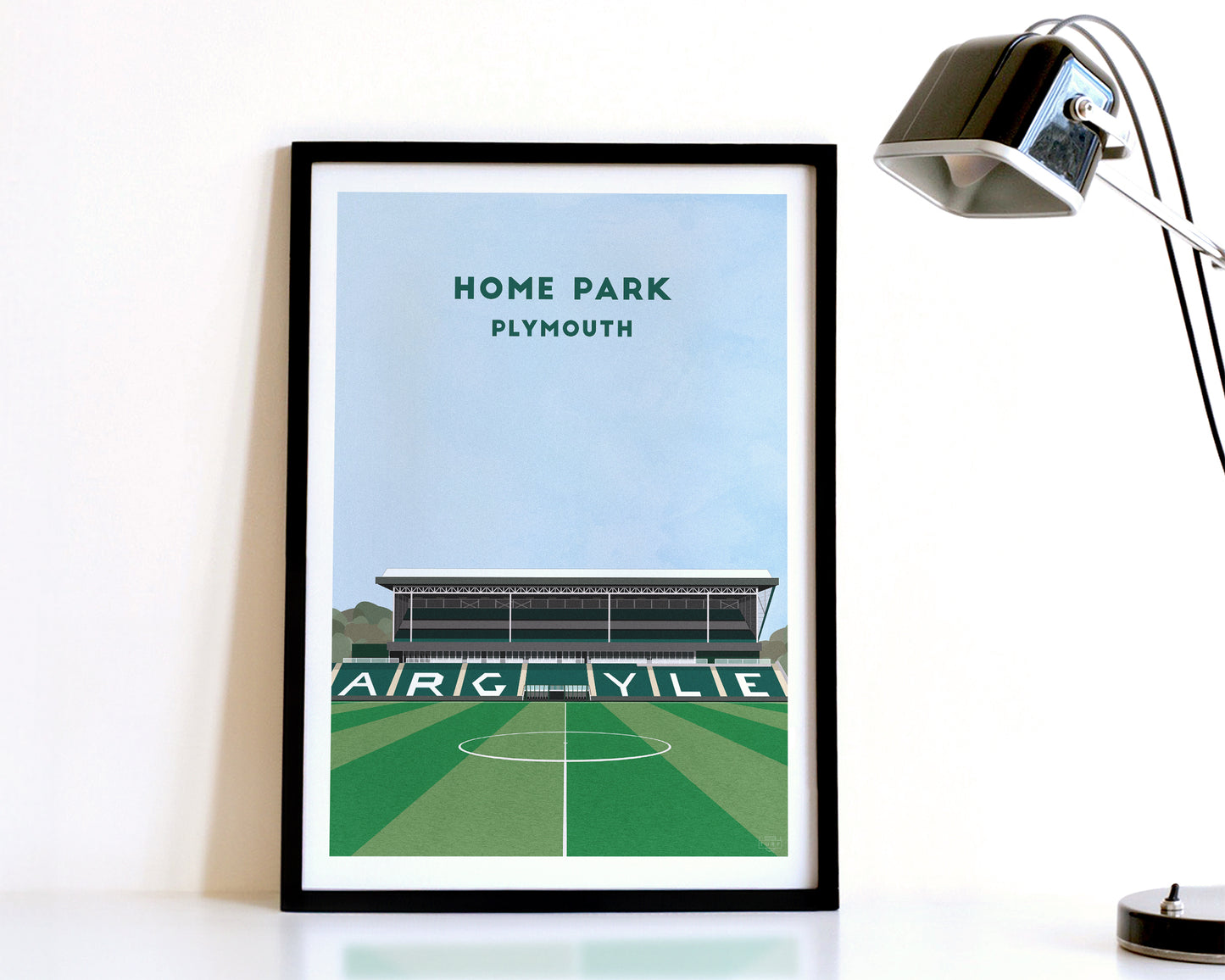 A modern style Plymouth Argyle Print, featuring a contemporary illustration of their home stadium the Home Park in Plymouth, displayed within a black frame.