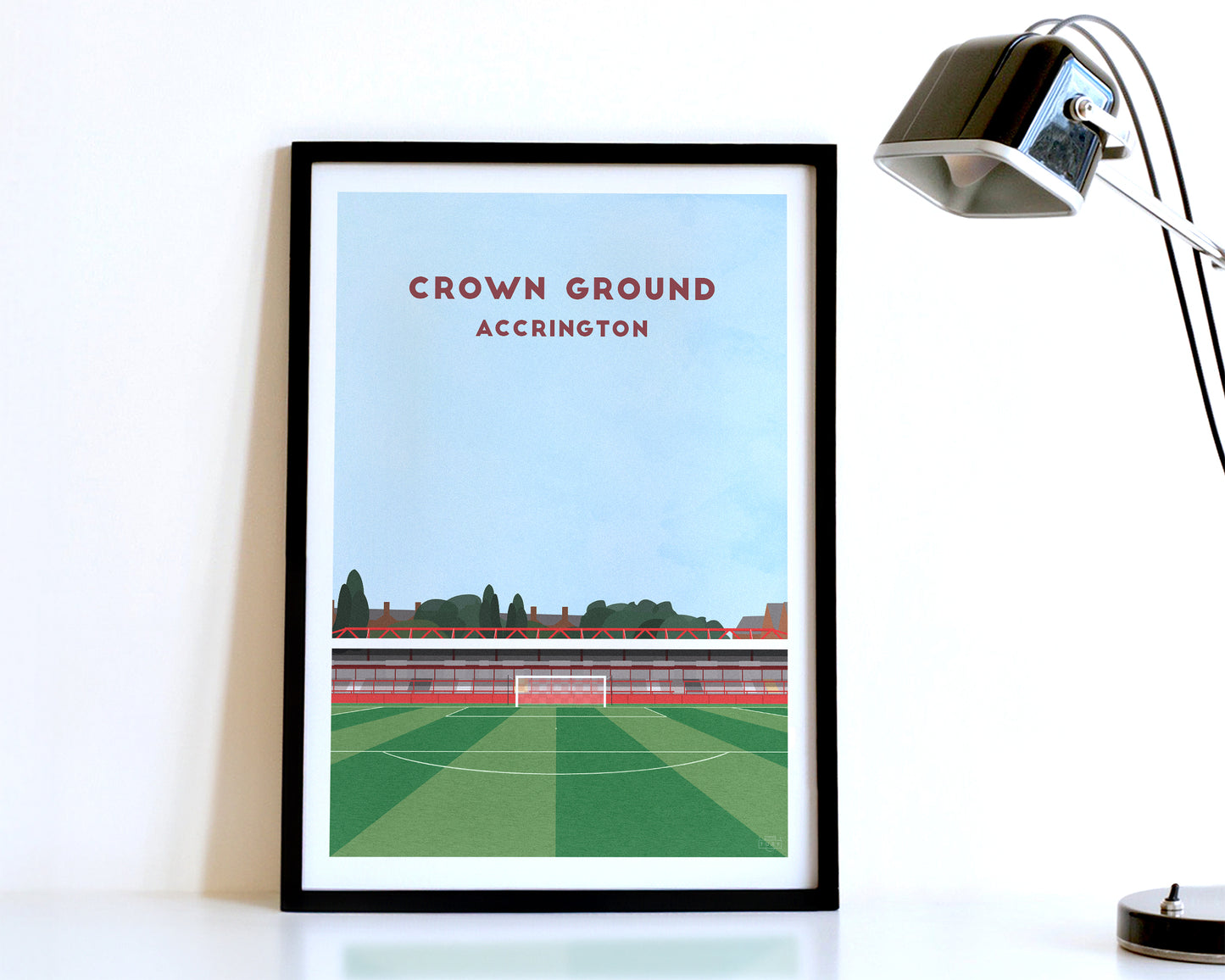 A modern style Accrington Stanley Print, featuring a contemporary illustration of their home stadium the Crown Ground / Wham Stadium in Accrington, displayed within a black frame.