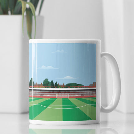 White Ceramic Mug with contemporary illustration of the Wham Stadium in Accrington, home to Accrington Stanley, showcasing a minimalist design with vibrant red stands, green football pitch, and the iconic stadium roof structure under a blue sky.