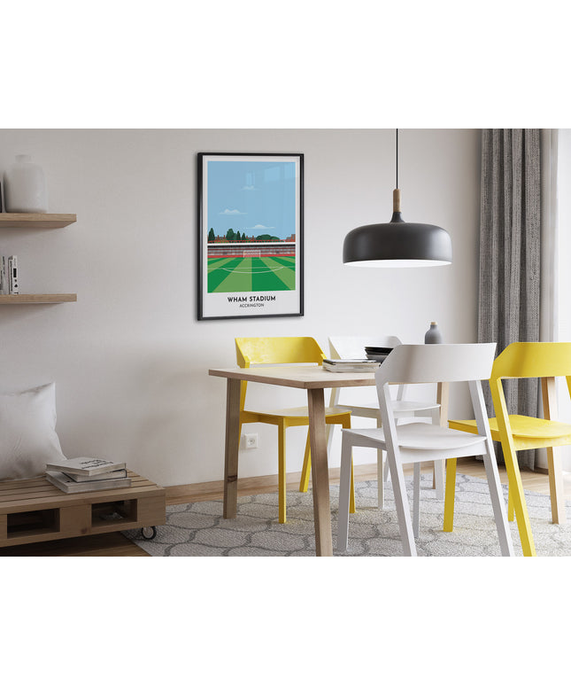 Framed illustrated print of Wham Stadium in Accrington, home to Accrington Stanley, showcasing a minimalist design with vibrant COLOUR stands, green football pitch, under a blue sky.