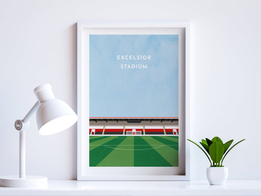 A contemporary style illustration of Airdrieonians' football stadium, the Excelsior Stadium, displayed as an art print within a white frame in a minimalist home office setting. 