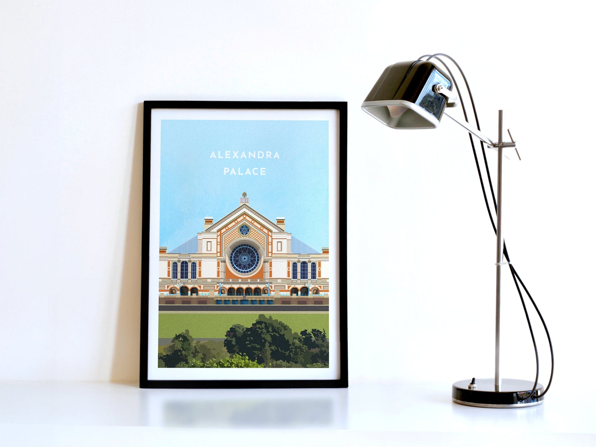 A contemporary style illustration of the Alexandra Palace, displayed as an art print within a black frame in a minimalist home office setting. 