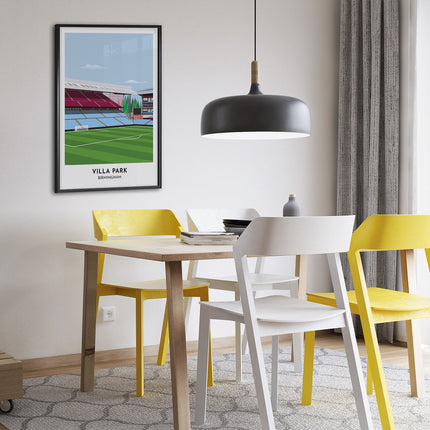 Framed illustration print of Villa Park in Birmingham, home to Aston V, showcasing a minimalist design with vibrant claret and blue stands, green football pitch, under a blue sky.