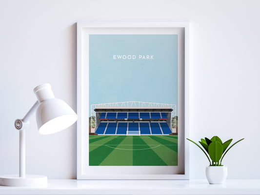 A contemporary style illustration of Blackburn Rovers' football stadium, Ewood Park, displayed as an art print within a white frame in a minimalist home office setting. 
