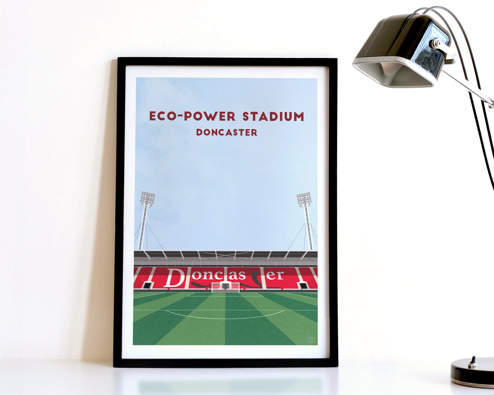 A modern style Doncaster Rovers Print, featuring a contemporary illustration of their home stadium the Eco-Power Stadium in Doncaster, displayed within a black frame.