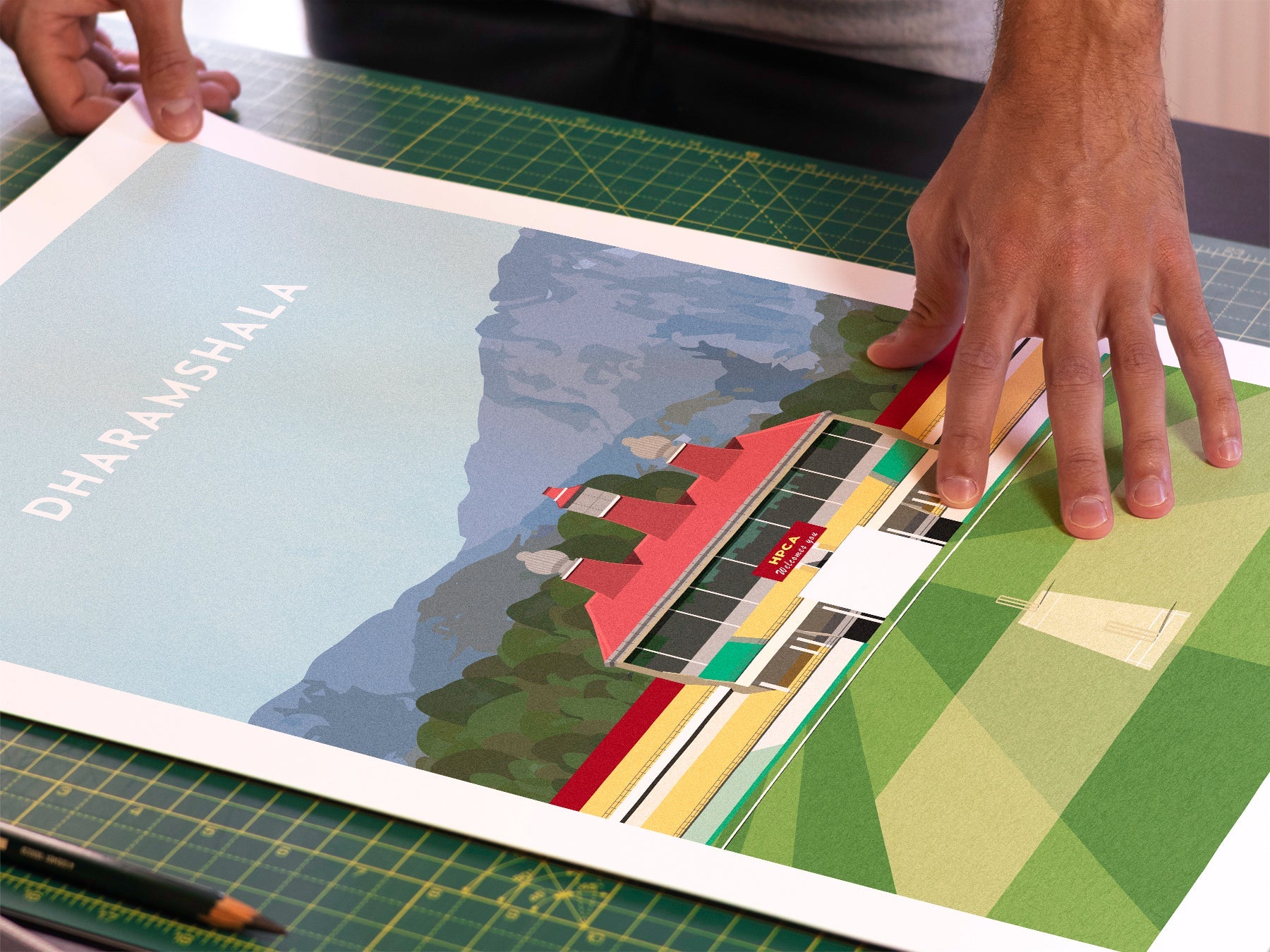 A photo in our printing studio, of one of our illustrated art prints of HPCA Stadium in Dharamshala after it has been printed and is about to be packaged.