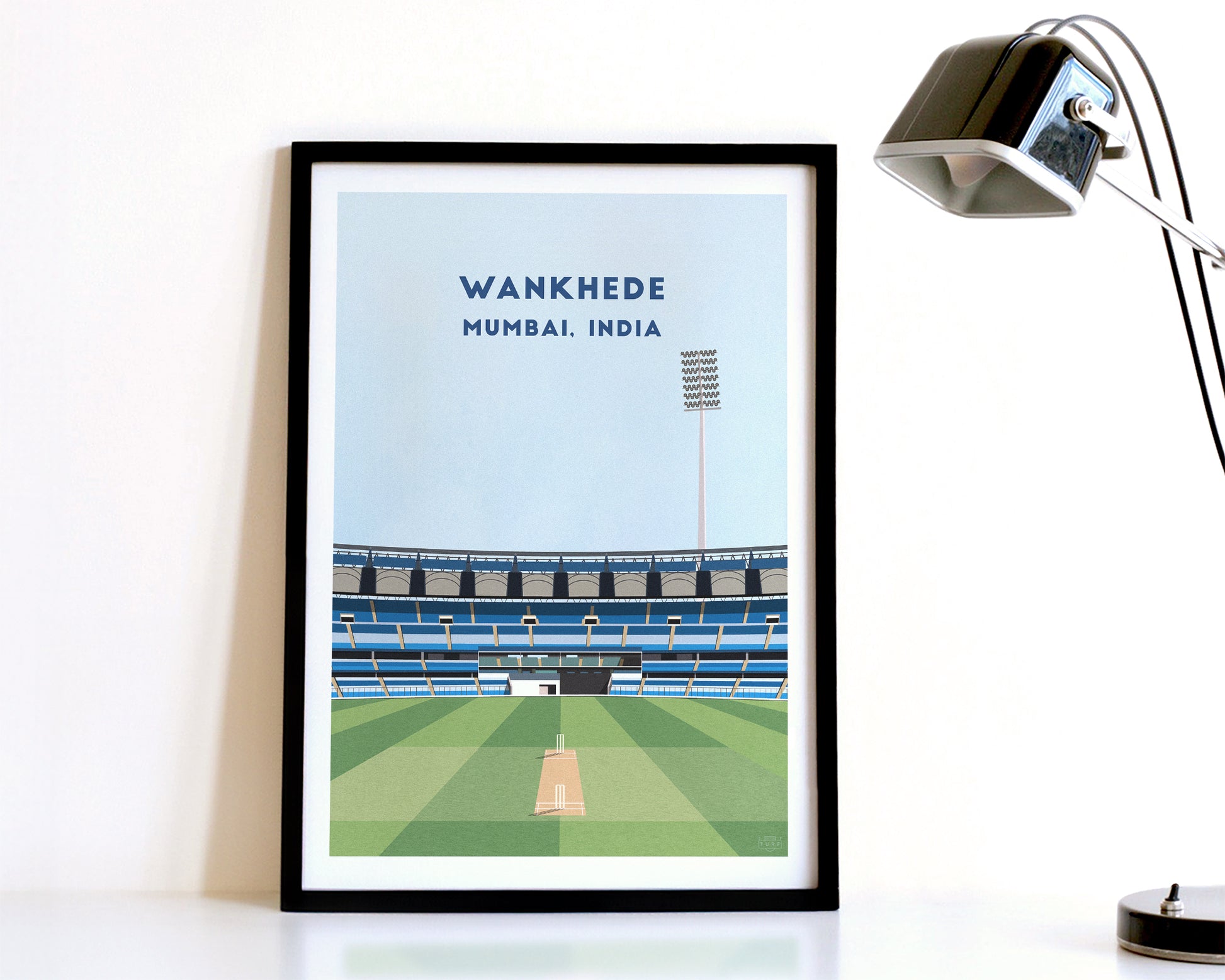 A modern style India Mumbai Cricket Print, featuring a contemporary illustration of their home stadium the Wankhede Stadium in Mumbai, India, displayed within a black frame.