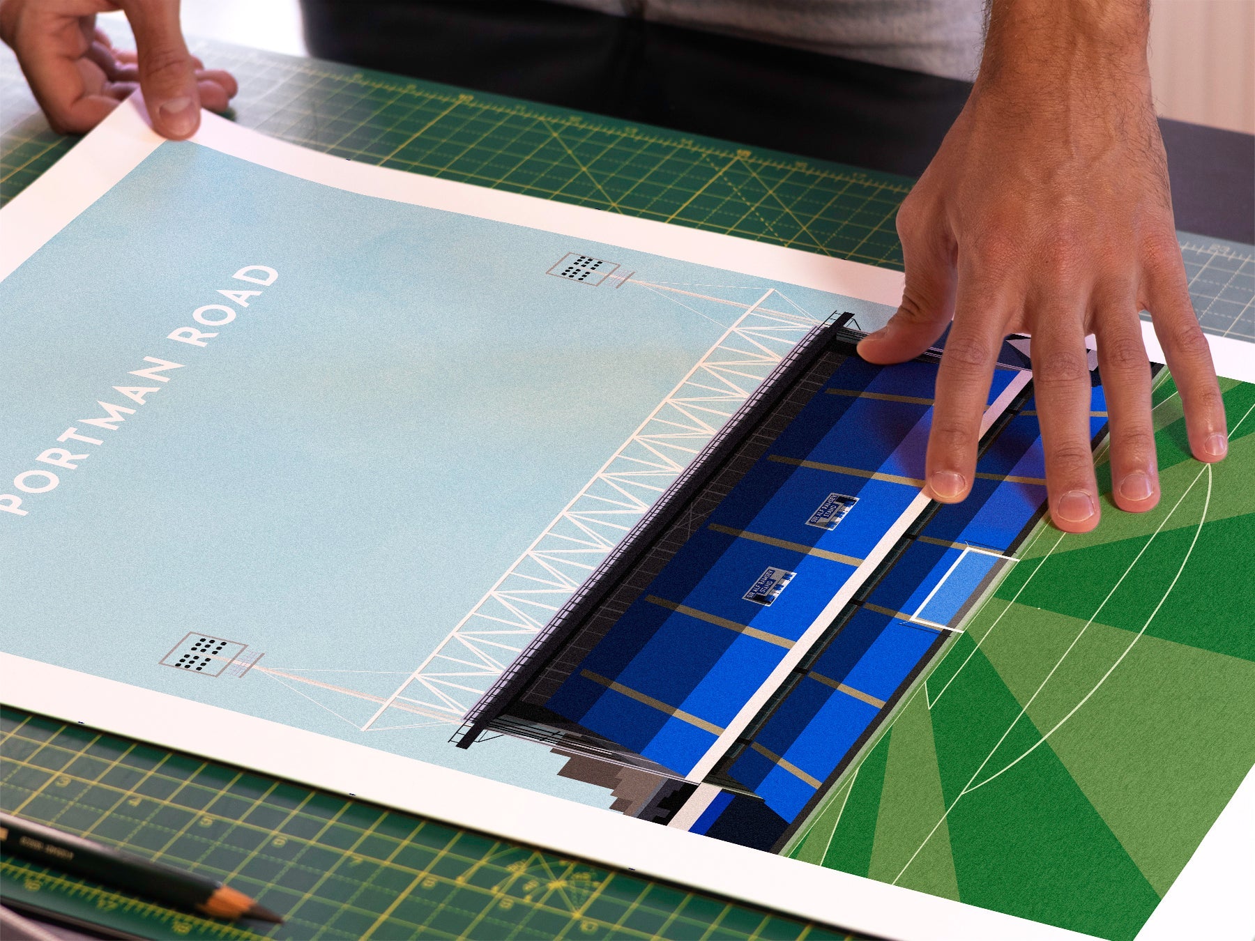 A photo in our printing studio, of one of our illustrated art prints of Portman Road after it has been printed and is about to be packaged.