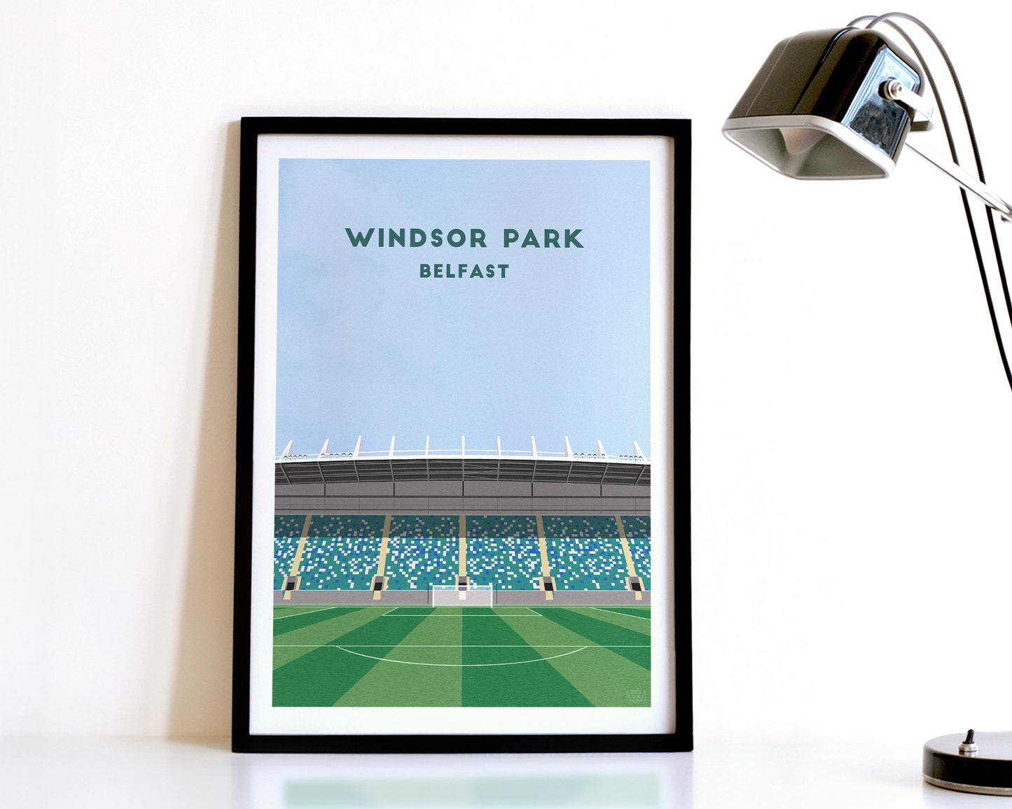 A modern style Linfield Print, featuring a contemporary illustration of their home stadium the WindsorPark in Belfast, displayed within a black frame.