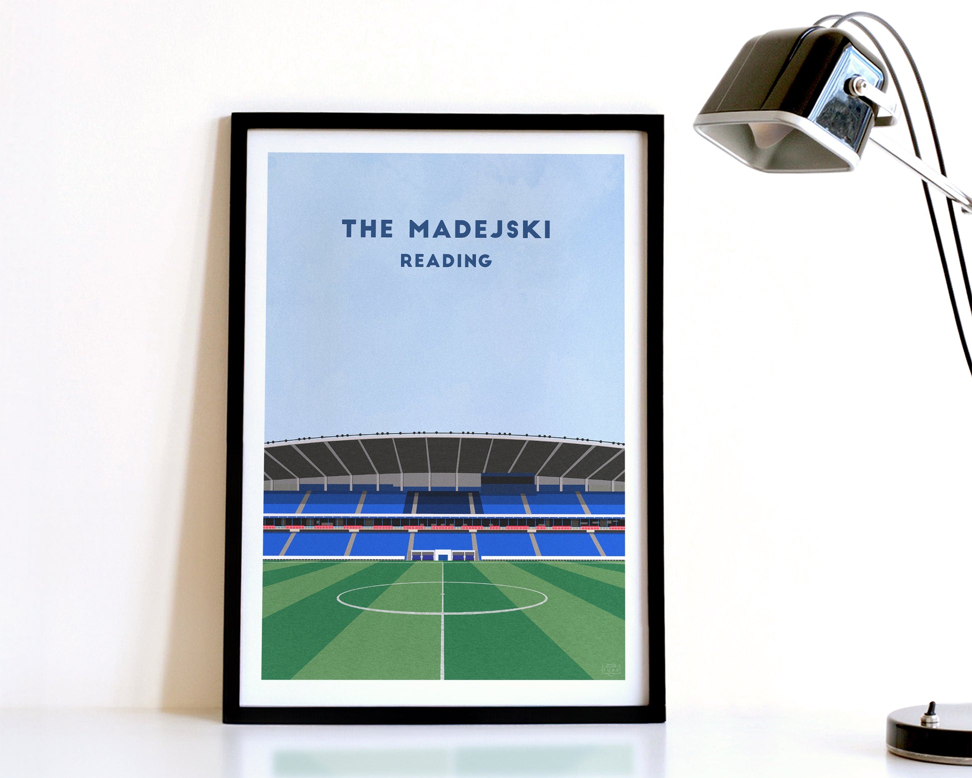 A modern style Reading FC Print, featuring a contemporary illustration of their home stadium the Madejski Stadium in Reading, displayed within a black frame.