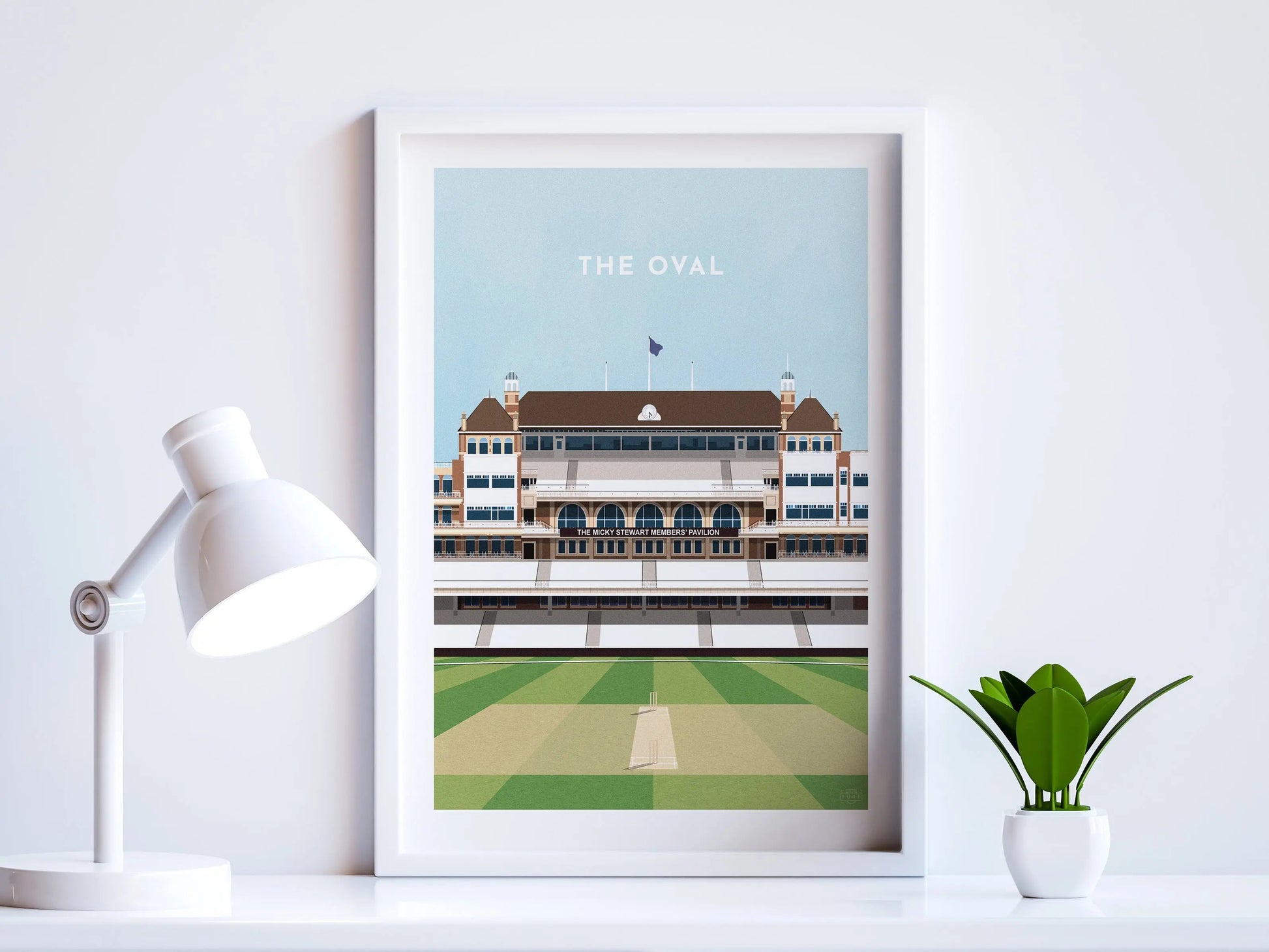 A contemporary style illustration of England and Surrey's cricket stadium, The Oval, displayed as an art print within a white frame in a minimalist home office setting. 