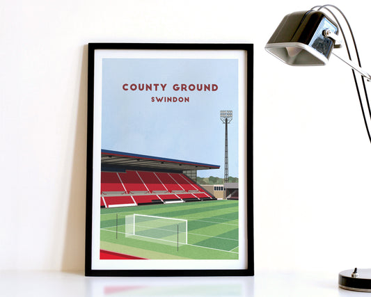 A modern style Swindon Town Print, featuring a contemporary illustration of their home stadium the County Ground in Swindon, displayed within a black frame.